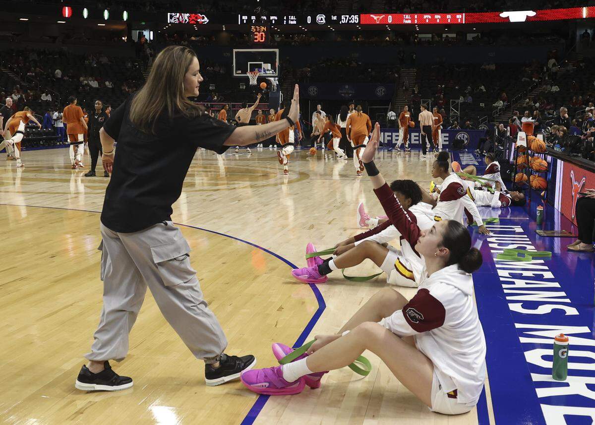 South Carolina sports performance coach Molly Binetti greets Alicia Tournebize while warming up for their basketball game in the SEC Tournament, against Texas at the Bon Secours Wellness Arena on March 8.