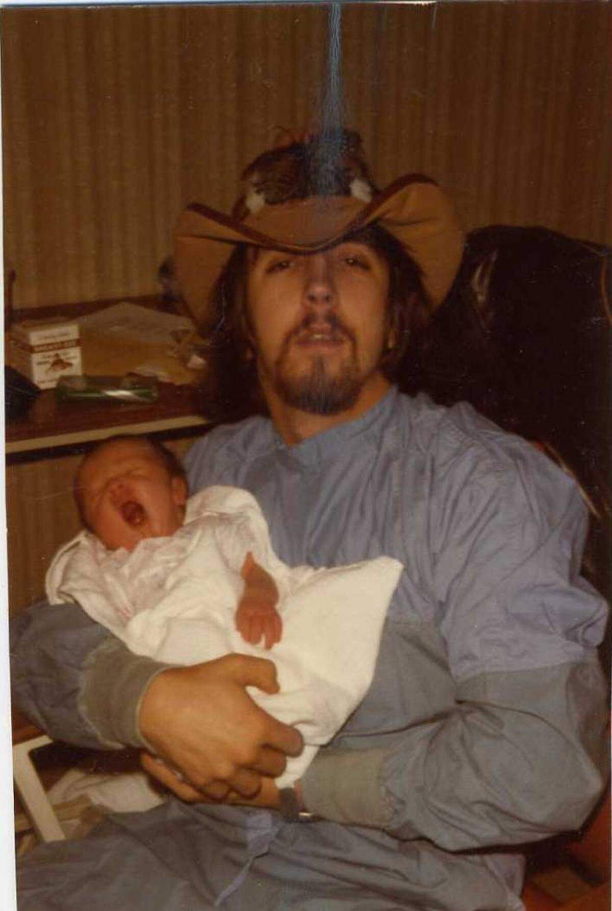 Convicted murderer Mitchell Sims holds his young son Michael, before Mitchell was arrested for killing three people in 1985. The older Sims was sent to death row, and his son went on to found his own church.