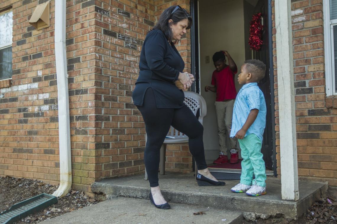 CJ Parker, 10, brushes his hair while his teacher, Diana Pearson opens a pack of chalk she brought for his brother, King Gary, 4. Pearson teaches fifth grade at Lakeview Elementary School and will visit her students on the weekend.