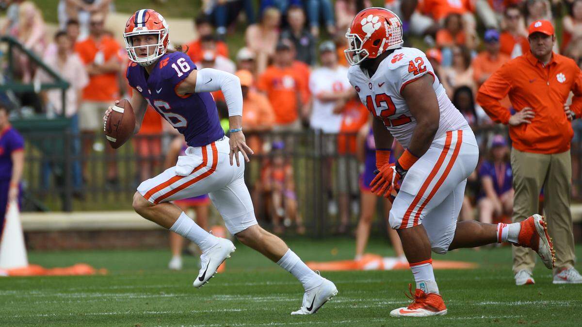 Clemson Tigers quarterback Trevor Lawrence (16) looks to throw under pressure from Clemson Tigers defensive lineman Christian Wilkins (42) during the Spring Game at Memorial Stadium.