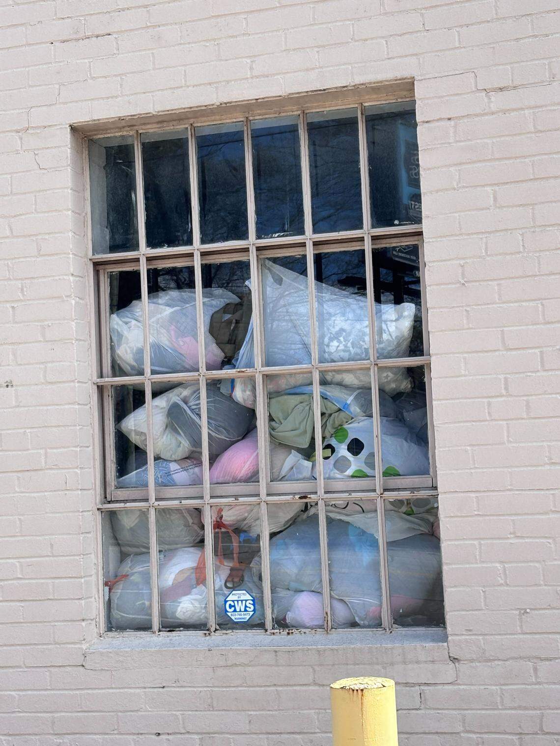 A stack of garbage bags stuffed with fabric is piled inside a window of the currently closed Salvation Army Family Store on Millwood Avenue in Columbia. The thrift store is closed because of damage to the building, and won’t reopen until at least August.
