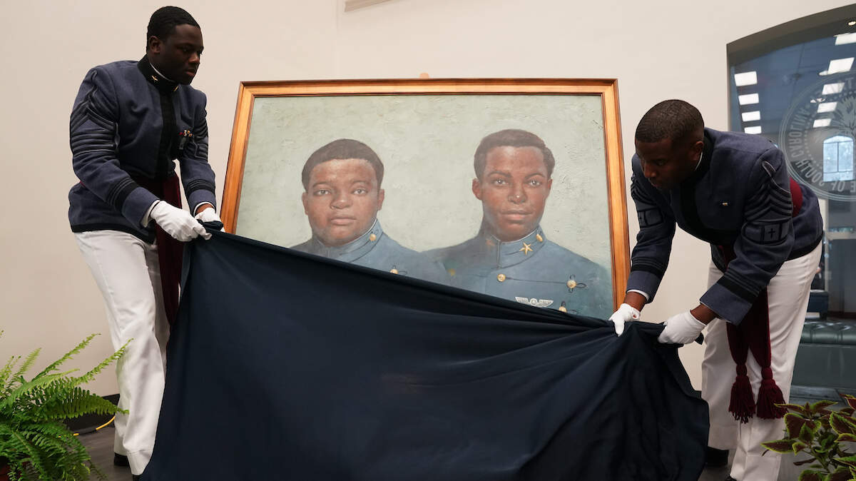 Two Citadel cadets unveil a portrait of Charles Foster, class of 1970, and Joseph Shine, class of 1971, during a portrait presentation ceremony on The Citadel campus Nov. 13, 2021. Foster and Shine were the military school’s first two African American cadets.