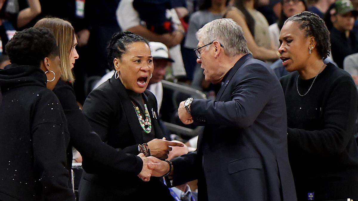 Head coach Dawn Staley of the South Carolina Gamecocks and head coach Geno Auriemma of the UConn Huskies exchange words during the final seconds of the fourth quarter in the Final Four of the NCAA Women's Basketball Tournament at Mortgage Matchup Center on April 3, 2026 in Phoenix, Arizona.