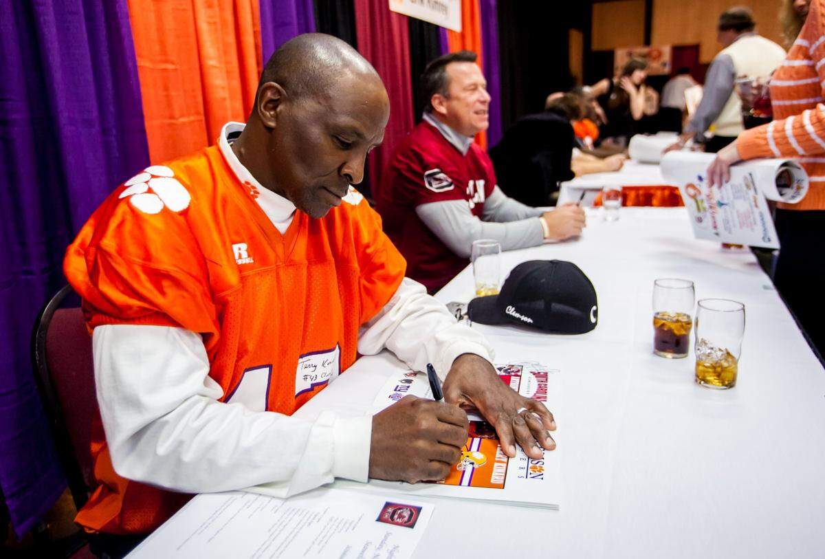 Clemson Tigers legend Terry Kinard signs an autograph during A Night with The Stars at Seawells, a Clemson/South Carolina fundraising event to benefit the Palmetto Health Richland Trauma Unit on Nov. 24, 2013.
