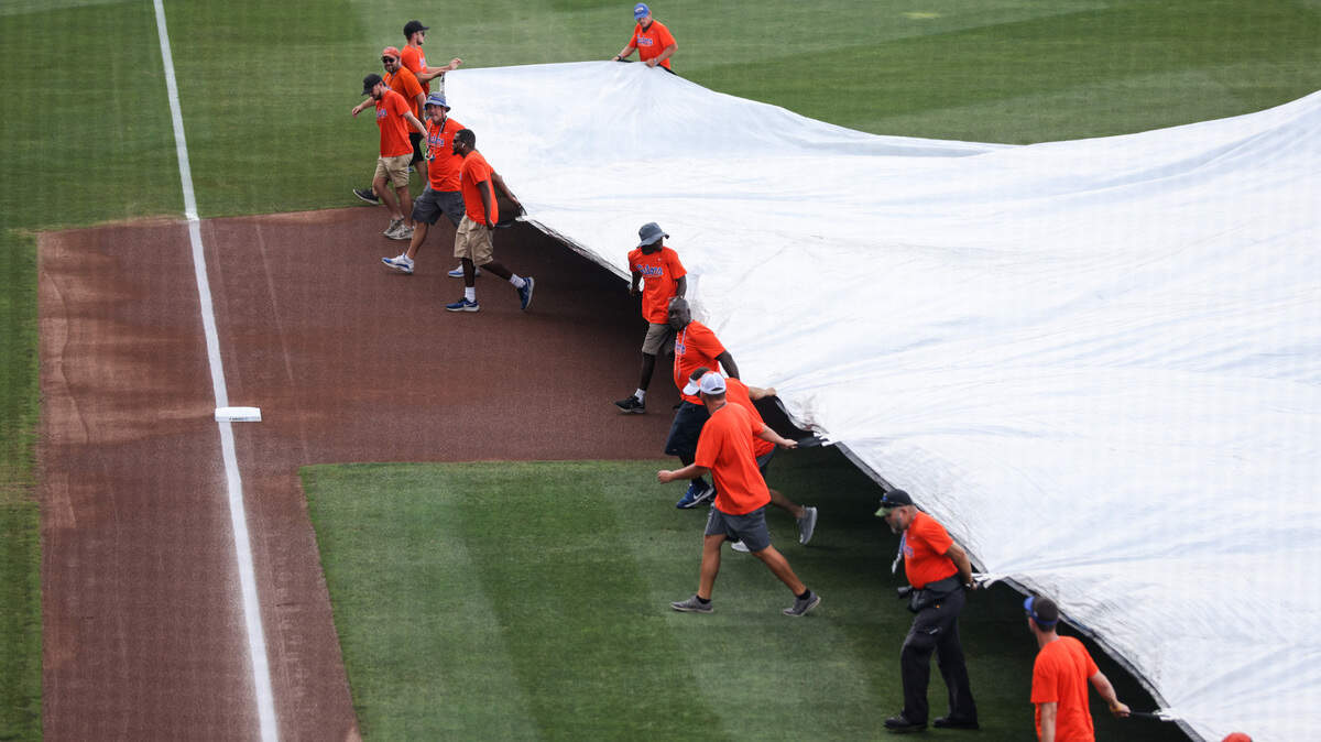 Members of the grounds crew cover the field with a tarp during a rain delay before South Carolina’s game against Florida in the Super Regional round of the 2023 NCAA College Baseball Championship at Condron Ballpark in Gainesville on Saturday, June 10, 2023.