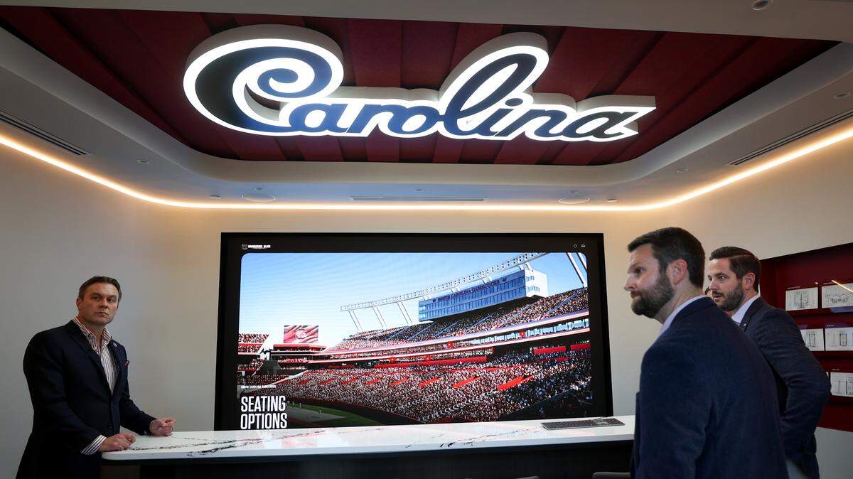 South Carolina Athletic Director Jeremiah Donati, left, explains how the university is promoting new luxury seating at Williams-Brice Stadium. An elaborate preview center is now located in the Bignon Gameday Center, adjacent to the stadium. At right is Dan Stahl, chief revenue officer for the Gamecock Club and Drew Turner, vice president of premium seating.