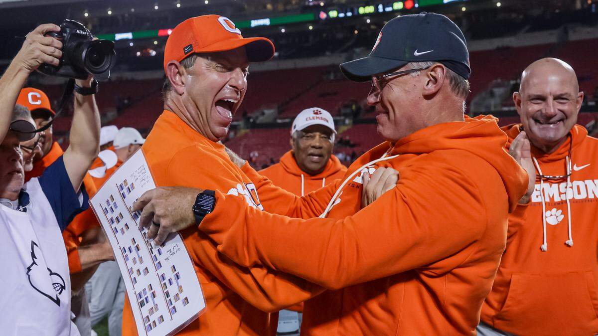 Head coach Dabo Swinney of the Clemson Tigers (left) celebrates after the NCAA football game between the Louisville Cardinals and the Clemson Tigers at L&N Federal Credit Union Stadium on November 14, 2025 in Louisville, Kentucky.