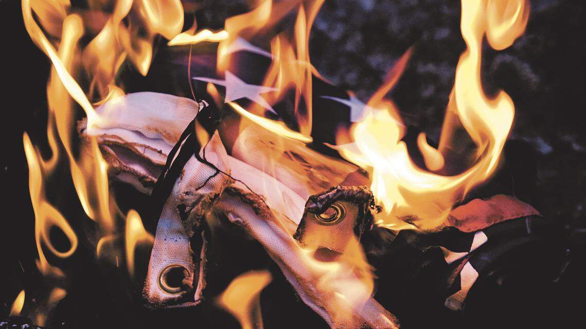 This file photo shows an American flag being burned, and an investigation is underway after 21 flags were destroyed at a South Carolina cemetery on July 4.