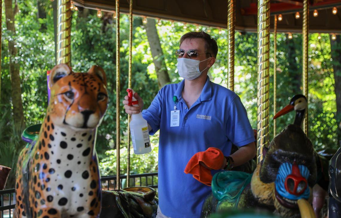 Green Hughen cleans animals on the carousel between riders at the Riverbanks Zoo. To help with social distancing every other row is seated when the ride is in operation.