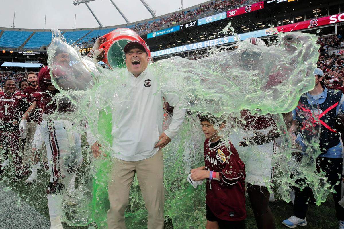 South Carolina Gamecocks head coach Shane Beamer is doused with Gatorade shortly before his team defeated North Carolina at the Dukes Mayo Bowl at Bank of America Stadium in Charlotte, North Carolina on Thursday, December 30, 2021.