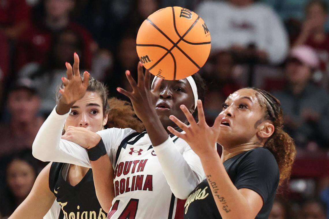University of South Carolina's Agot Makeer (44) and Anderson's Kyia Barrett (23) and Ciara Harris (1) juggle a loose ball during the first half of action at the Colonial Life Arena on Friday Oct. 24, 2025.