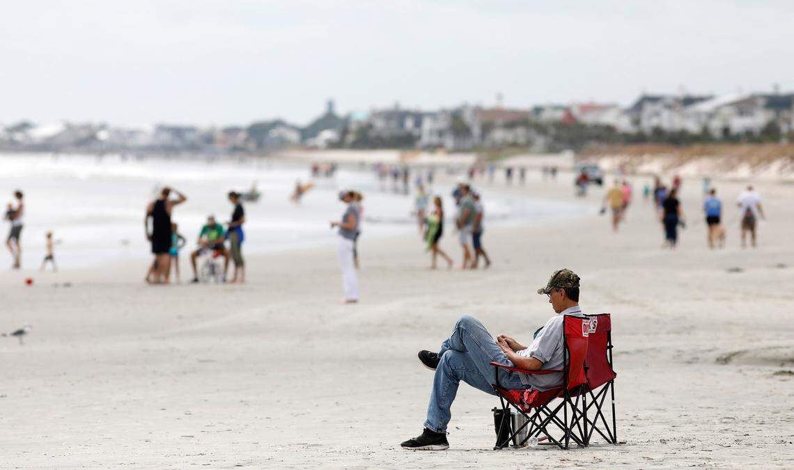 FILE - In this Sept. 13, 2018, file photo, beach goers hang out at the Isle of Palms, S.C., as Hurricane Florence spins out in the Atlantic ocean. For years, offshore drilling has stirred emotions and vocal opposition along South Carolina’s coast, with many residents expressing concern the practice could cause irreparable harm to the coastal areas that are the heart of South Carolina’s $20 billion tourism industry.