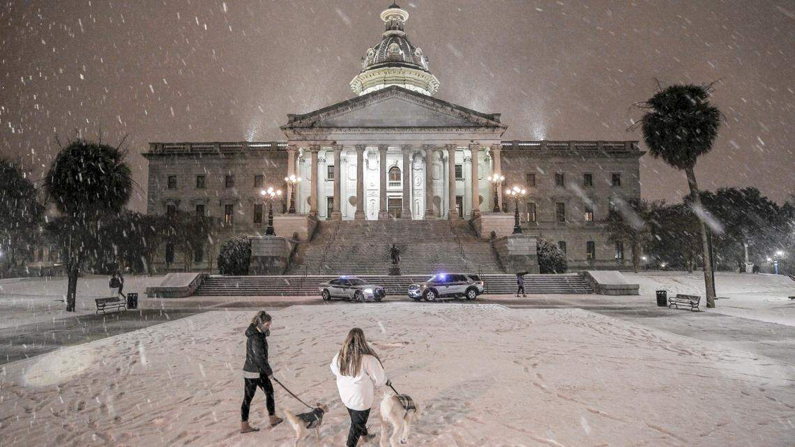 Visitors to the South Carolina statehouse grounds take in the falling snow on Friday, Jan. 21, 2022 in Columbia, S.C. (Travis Bell/Statehouse Carolina)