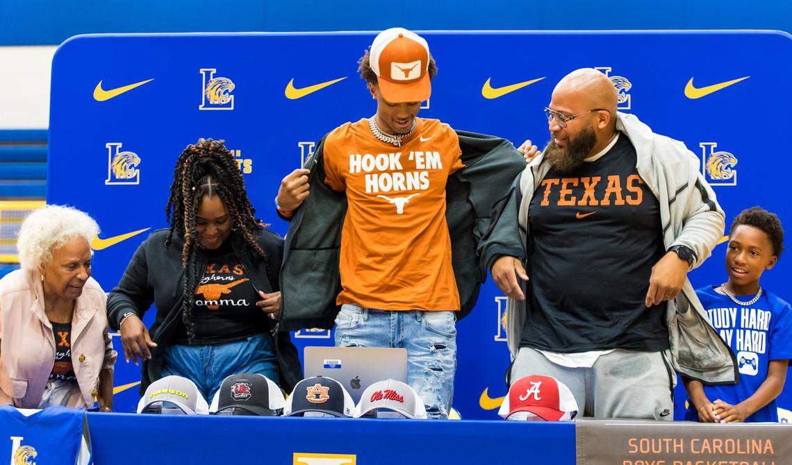 Lexington High School student/athlete Cam Scott dons Texas Longhorn gear, indicating where he will player college basketball, during his commitment announcement at his high school in Lexington, SC, Friday, August 11, 2023. With him also donning Texas gear are his grandmother Eleanor Greene; mother Alisha Coles; father Armet Coles; along with younger brother Armet Coles III.