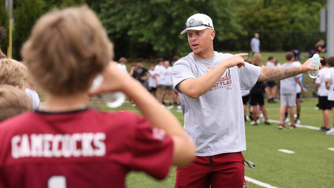 South Carolina quarterback Spencer Rattler works with kids attending the Spencer Rattler FlexWork Football Camp at Dreher High School in Columbia on Saturday, May 20, 2023.