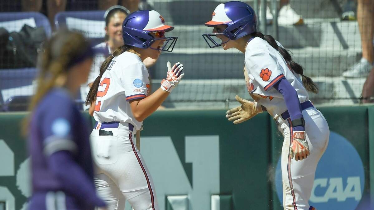 Clemson senior Aby Vieira, right, celebrates with teammate Julia Knowler (12) after a squeeze bunt by Marian Collins during the top of the ninth inning of the NCAA Softball Clemson Regional at McWhorter Stadium in Clemson, S.C.., Saturday, May 17, 2025.
