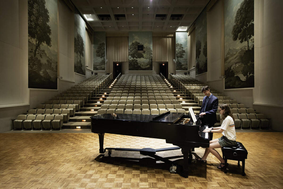 A student and faculty member rehearse in Daniel Hall.