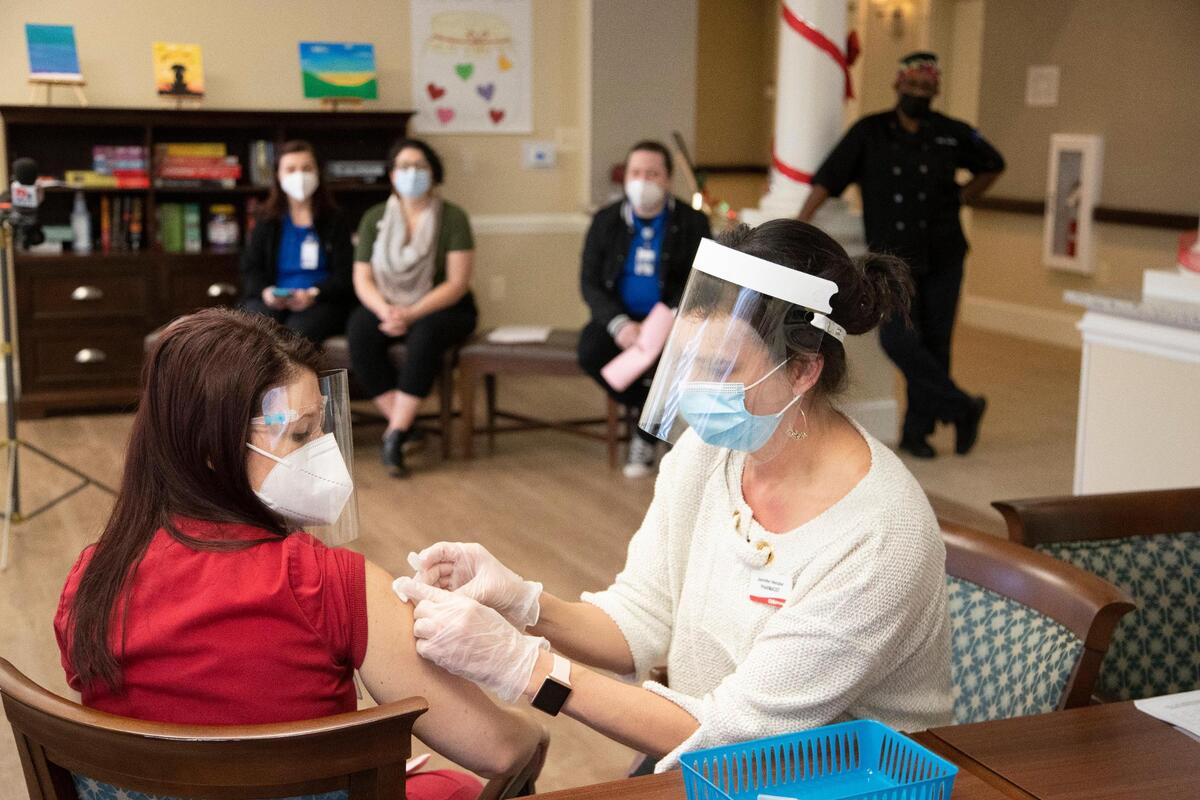 Dr. Jennifer Henzler gives the first shot of the coronavirus vaccine at Wellmore of Lexington on Wednesday, December 30, 2020. CVS administered the Moderna coronavirus vaccine on Wednesday, and will administer a second shot soon.