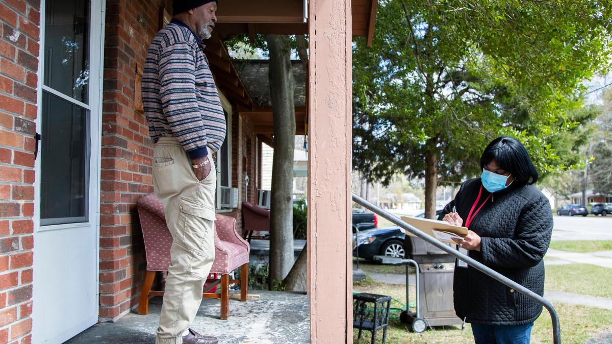 Robert Frasier gives his name and contact information to Sondra Jackson at his home on Colonial Drive on Saturday, March 20, 2021. Frasier says he had a hard time registering for the coronavirus vaccine online, and was glad to see volunteers walking around to help him register.