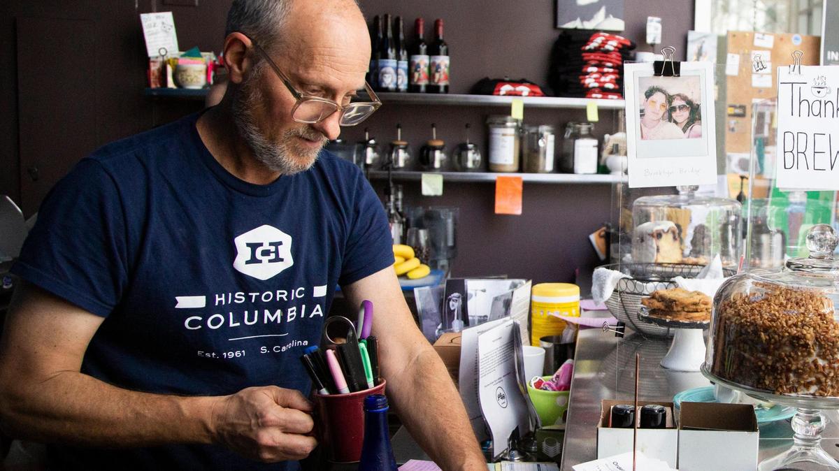 Sean McCrossin, owner of Drip, a coffee shop in downtown Columbia, South Carolina, cleans behind the counter on Thursday, March 12, 2020.
