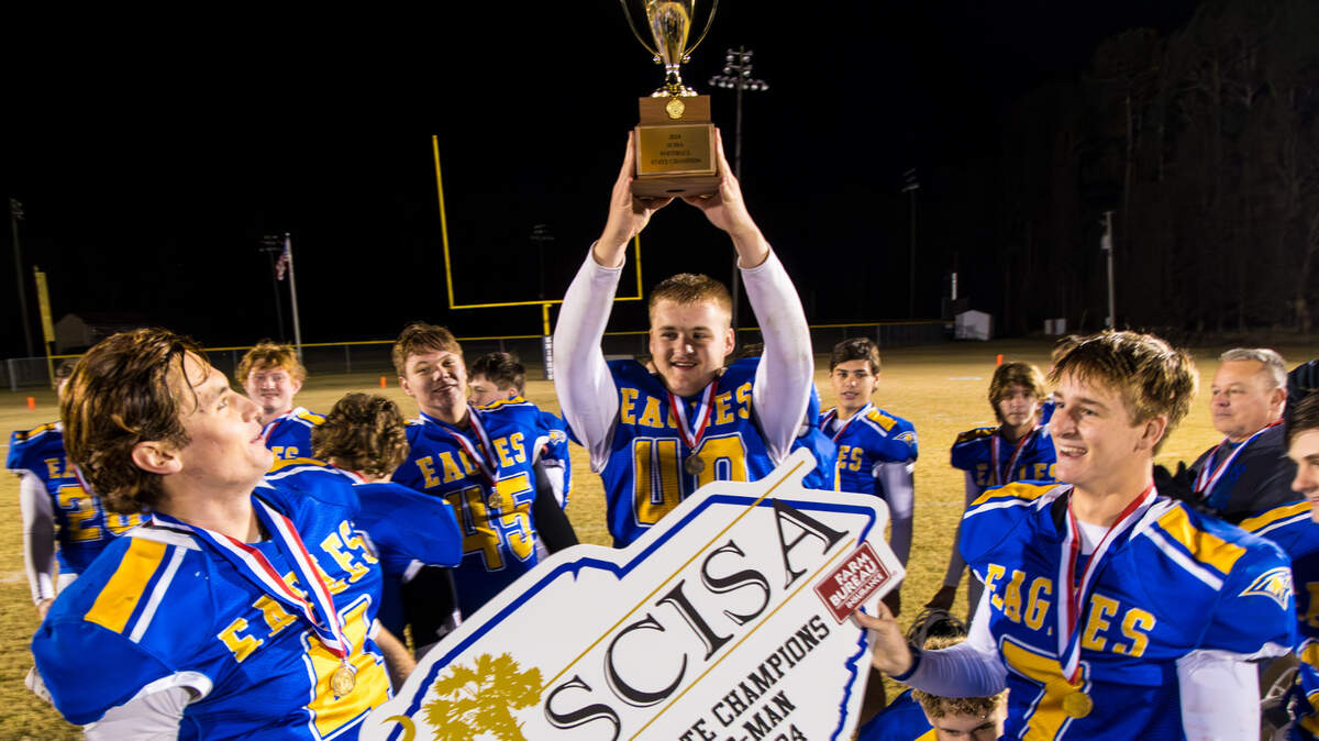Richard Winn Eagles Charlie Bonds (4), Justin Autry (40) and Josh Tyndall (7) celebrate winning following their win over the Laurens Crusaders in the SCISA 8-man state championship game at W. Wyman King Academy in Batesburg-Leesville, SC, 11/22/24.