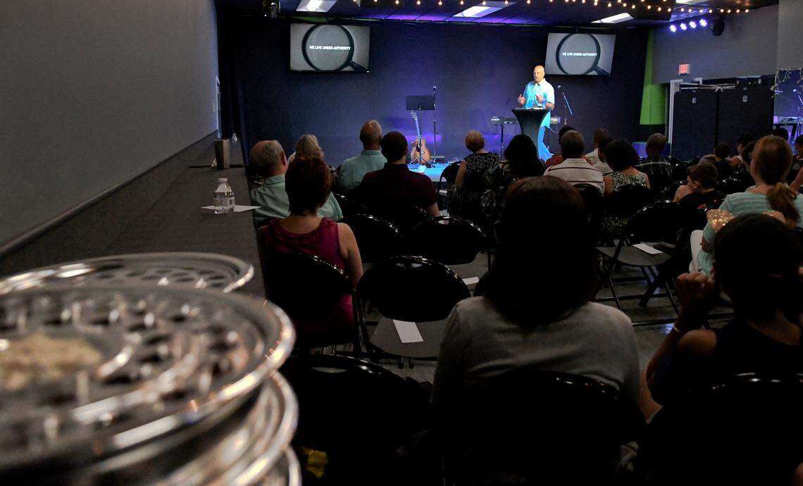Pastor Michael Beaumont, with Live Oak Christian Church, preaches before his congregation on Sunday, August 5, 2018 at Bluffton School of Dance in Bluffton as he discusses the Scripture of Titus. In the foreground rests communion trays which sit upon make-shift table that cover a ballet barre along the wall. The church stores their equipment in a shipping-type container on the dance school grounds in which five volunteers with the church hang up signage, unpack chairs, cover mirrors and windows in little more than an hour. The church pays a nominal rent at the dance facility and have vowed to leave much of the digital infrastructure they installed when they build their own facility.