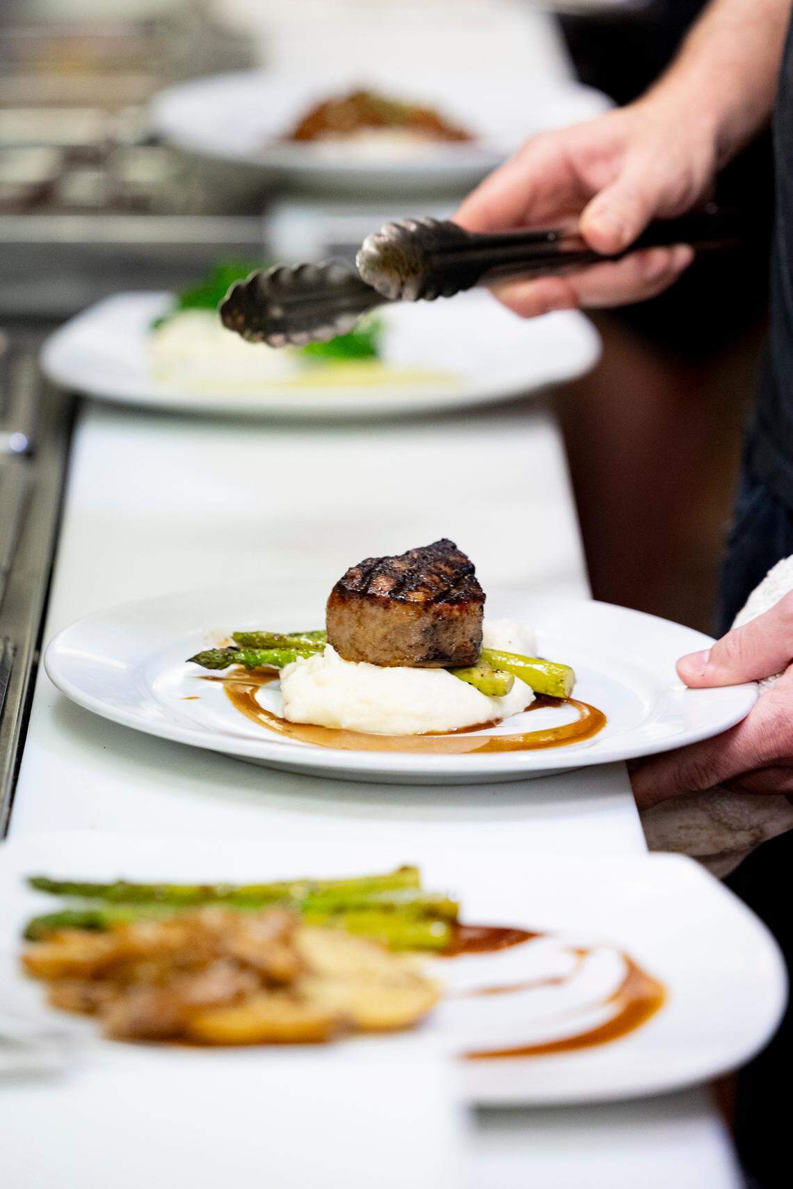 Daniel Whalen plates a dish at Saluda’s Restaurant on Thursday, Feb. 8, 2024.