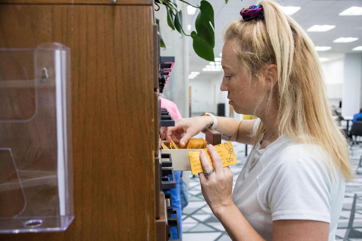 Elizabeth Thomas looks for seeds in an old card catalogue at the Richland County Library Main branch on Tuesday, July 19, 2022. The seed library is one of the many non-book lending services the library offers.