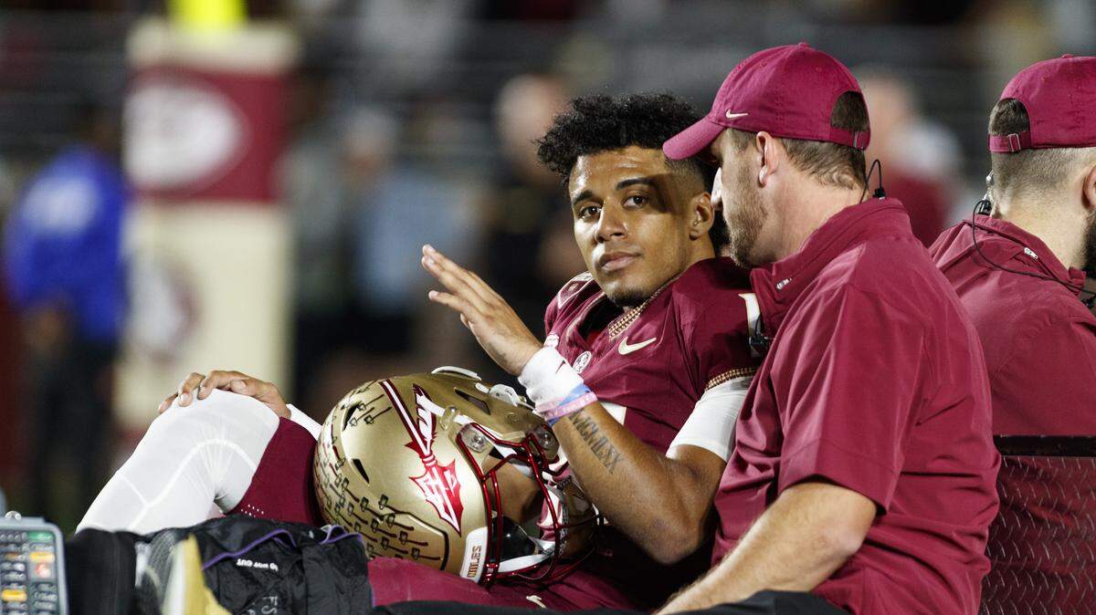 Nov 18, 2023; Tallahassee, Florida, USA; Florida State Seminoles quarterback Jordan Travis (13) waves to fans while being carted off after an injury against the North Alabama Lions during the first quarter at Doak S. Campbell Stadium.