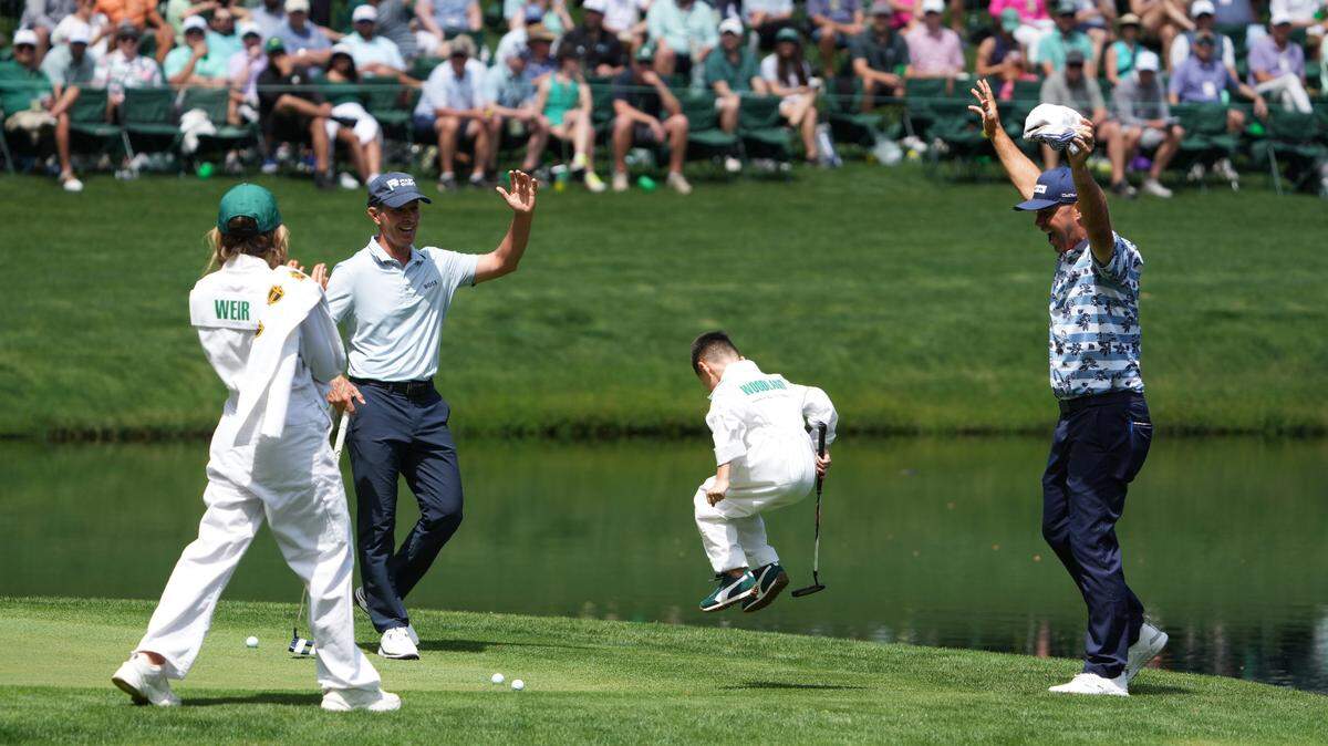 Mike Weir and Gary Woodland celebrate Woodland’s son Jaxson’s putt on No.9 during the Par 3 Contest at Augusta National Golf Club.