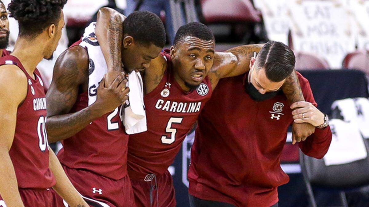 South Carolina’s Jermaine Couisnard is helped off the floor Saturday at Colonial Life Arena.