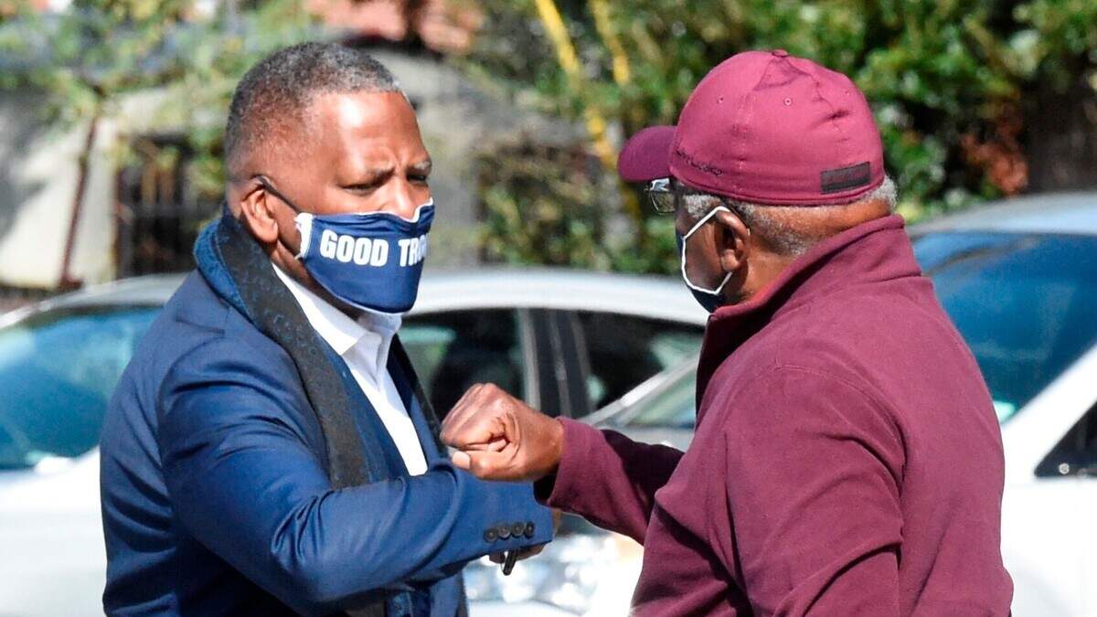 Steve Benjamin, left, mayor of Columbia, S.C., left, greets U.S. House Majority Whip Jim Clyburn, right, with an elbow bump outside a polling place on Tuesday, Nov. 3, 2020, in Columbia, S.C. (AP Photo/Meg Kinnard)