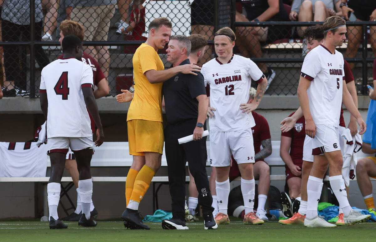 South Carolina goalkeeper Ben Alexander (1) hugs head coach Tony Annan before the Gamecocks’ game against Tigers in Columbia on Friday, August 30, 2024.