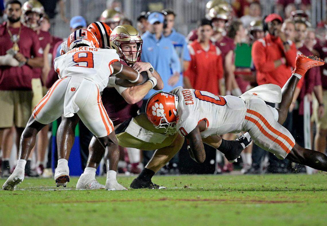 Oct 5, 2024; Tallahassee, Florida, USA; Florida State Seminoles quarterback Brock Glenn (11) is tackled by Clemson Tigers linebacker Barrett Carter (0) during the second half at Doak S. Campbell Stadium.