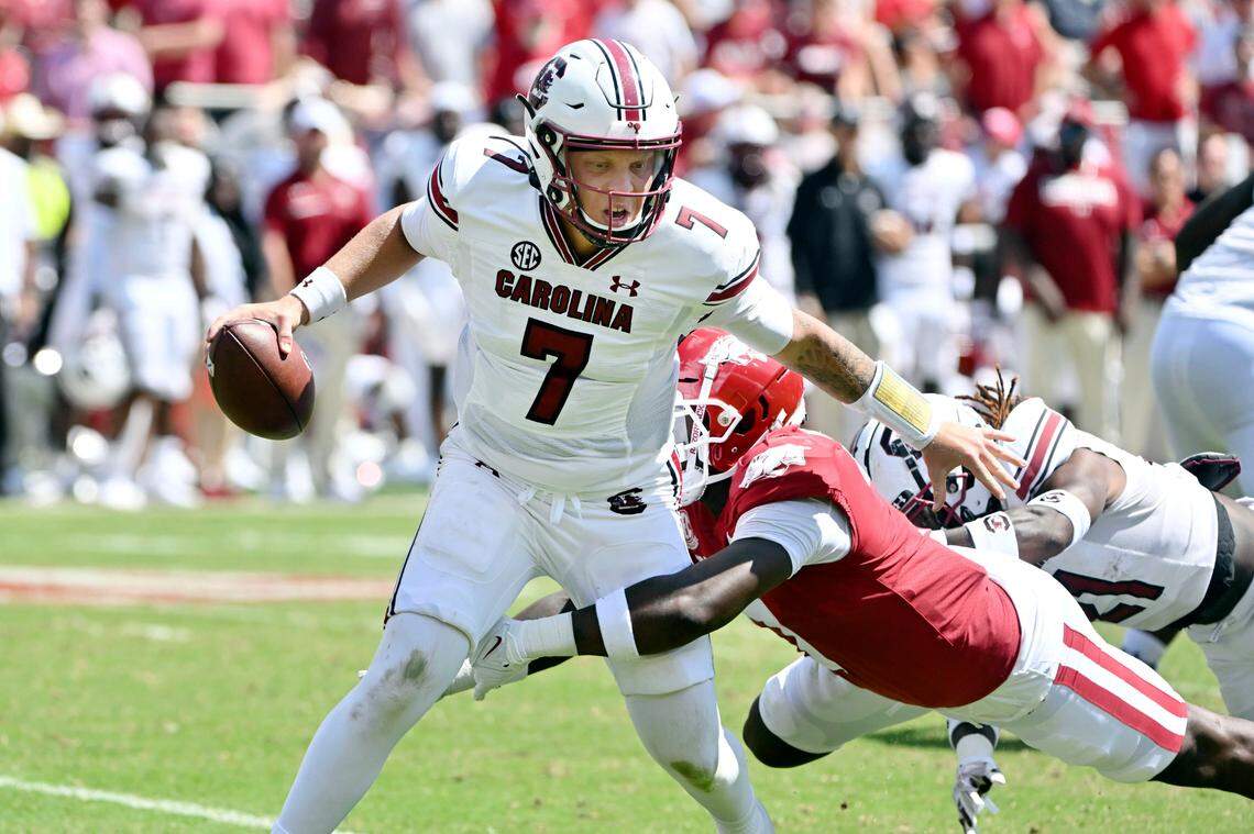 South Carolina quarterback Spencer Rattler (7) tries to get away from Arkansas defensive back Latavious Brini (7) during the second half of an NCAA college football game Saturday, Sept. 10, 2022, in Fayetteville, Ark. (AP Photo/Michael Woods)