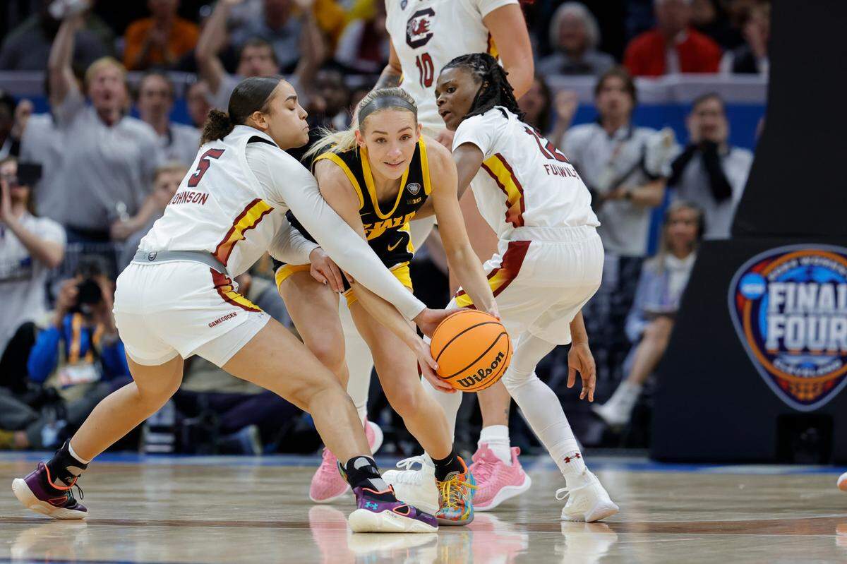 South Carolina’s Tessa Johnson (5) and MaLaysia Fulwiley (12) snag the ball from Iowa’s Kylie Feuerbach (4) during the National Championship game at the Rocket Mortgage FieldHouse in Cleveland, Ohio on Sunday April 7, 2024.