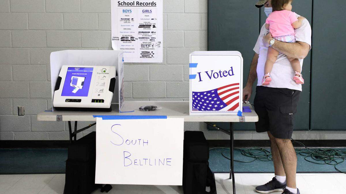 Joe Craig votes at Brennen Elementary School with his one-year-old daughter, Molly. Three precincts are combined at Brennen Elementary School. 6/9/20