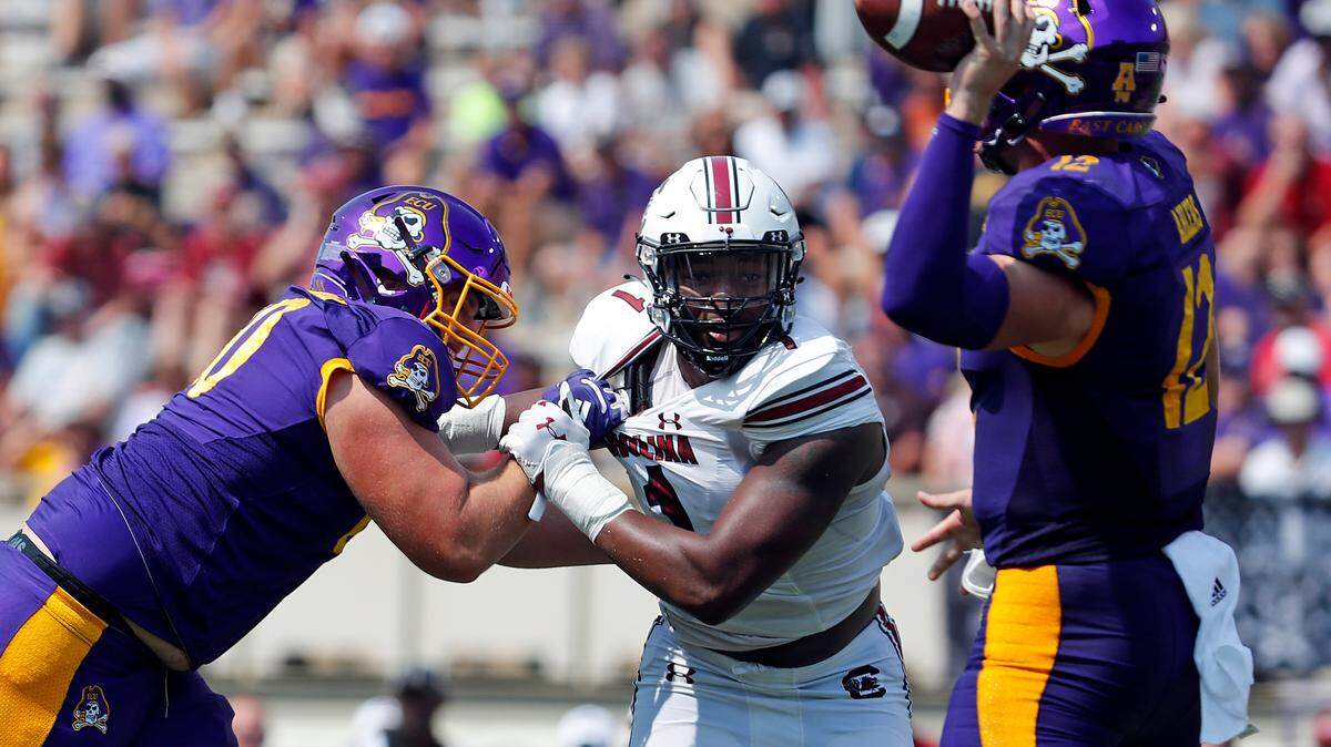 East Carolina’s Holton Ahlers (12) tries to avoid the rush of South Carolina’s Kingsley Enagbare (1) during the second half of an NCAA college football game in Greenville, N.C., Saturday, Sept. 11, 2021. (AP Photo/Karl B DeBlaker)