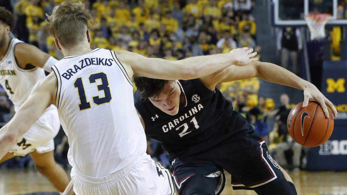 South Carolina forward Maik Kotsar (21) drives into Michigan forward Ignas Brazdeikis (13) in the first half of an NCAA college basketball game in Ann Arbor, Mich., Saturday, Dec. 8, 2018. (AP Photo/Paul Sancya)