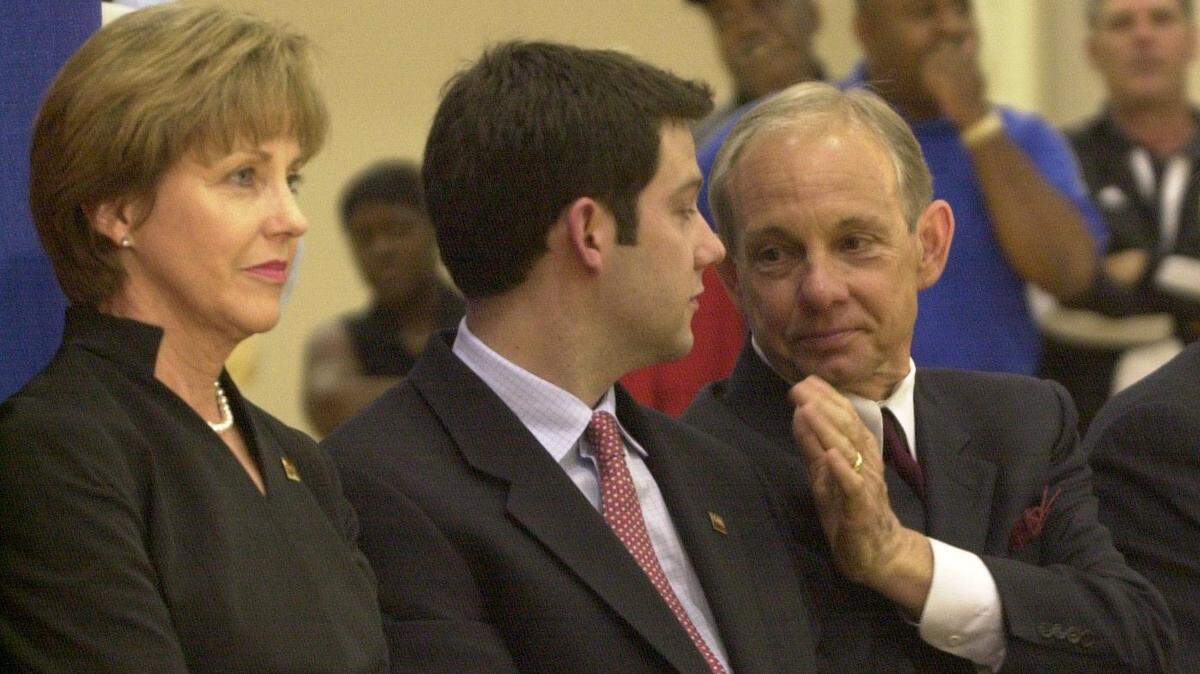 Dave Odom pats his son, Ryan, on the shoulder just before USC Athletics Director Mike McGee and USC President
John Palms introduced Odom as South Carolina coach in April 2001.