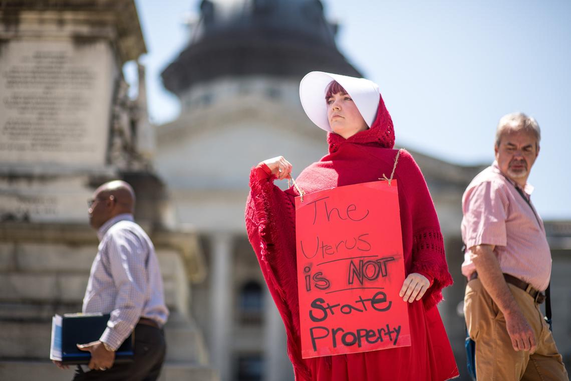 A demonstrator stands at the corner of Main and Gervais St. as part of a national “STOP THE BANS” day of action at the South Carolina statehouse, Tuesday, May 21, 2019, in Columbia, S.C. The rally was one many held on Tuesday in all fifty states in response top recent state bans on abortion.