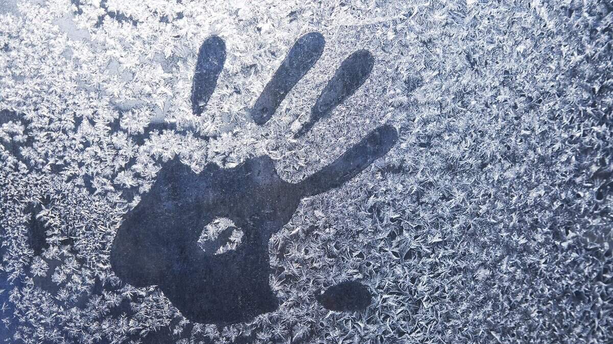 Hand trace on the frozen winter glass