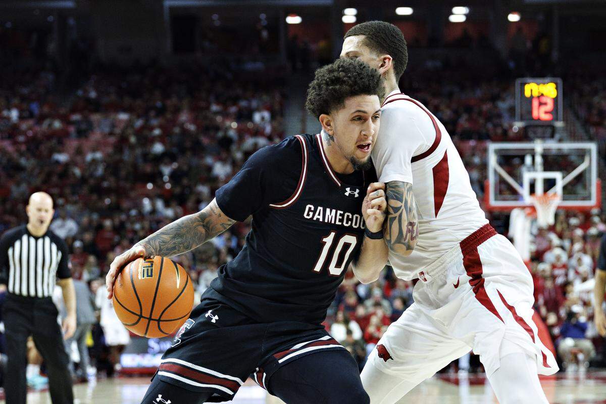 Myles Stute #10 of the South Carolina Gamecocks goes to the basket in the second half against Trevon Brazile #7 of the Arkansas Razorbacks at Bud Walton Arena on January 14, 2026 in Fayetteville, Arkansas. The Razorbacks defeated the Gamecocks 108-74.
