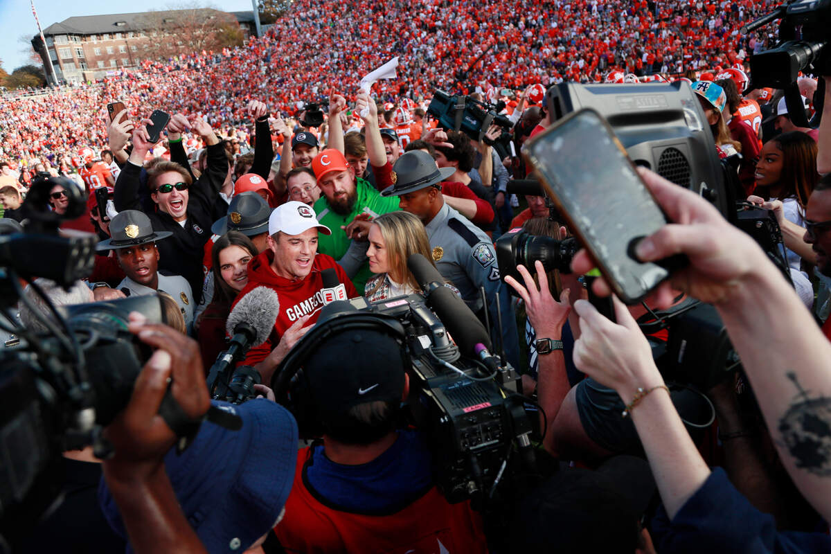 South Carolina head coach Shane Beamer is interviewed for live TV as he’s surrounded by a mass of fans on the field after his team beat Clemson on Saturday at Memorial Stadium.
