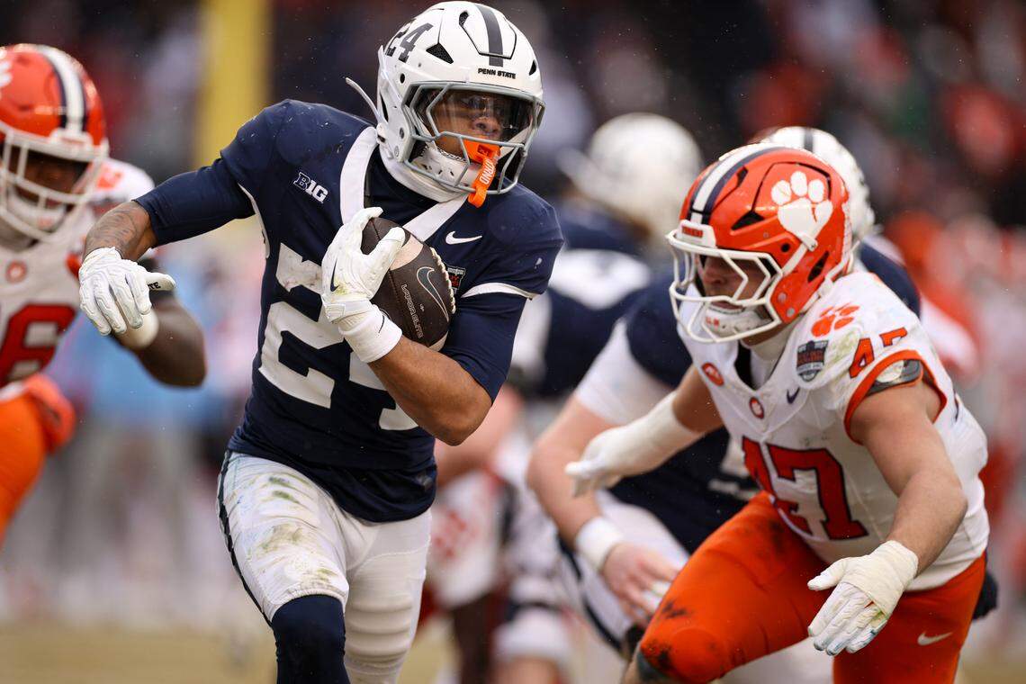 Corey Smith #24 of the Penn State Nittany Lions carries the ball as Sammy Brown #47 of the Clemson Tigers pursues the tackle during the 2025 Pinstripe Bowl at Yankee Stadium.