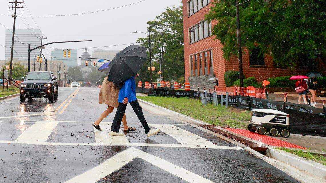 Students and a Grubhub delivery robot cross Main Street as Hurricane Helene hits Columbia, South Carolina on Thursday, September 26, 2024.