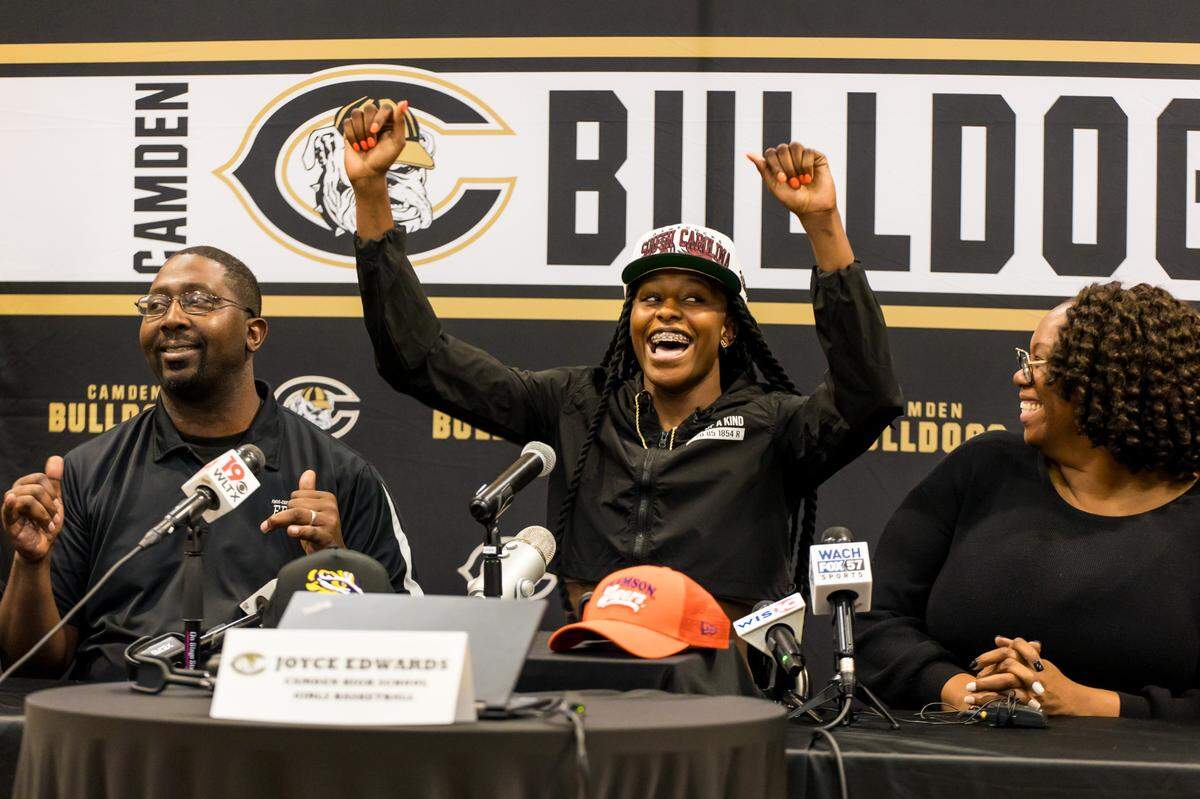 Camden High School basketball player Joyce Edwards celebrates after announcing her choice to play at the University of South Carolina over Clemson and LSU. Seated with her are her parents Rasheedah and Charlie Edwards.