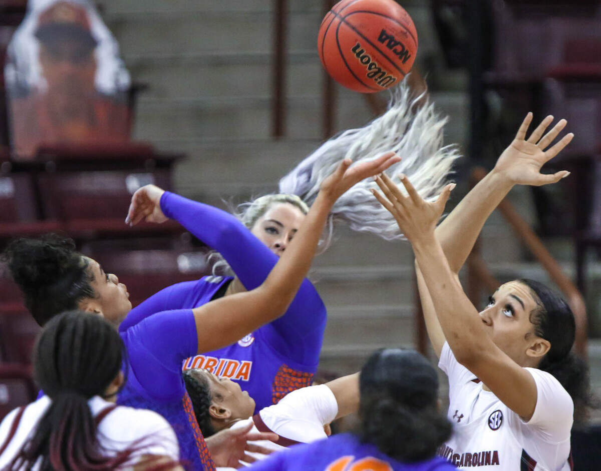 South Carolina Gamecocks guard Brea Beal (12) battles Florida forward Emily Sullivan (2) and Florida guard Lavender Briggs (3) for a ball during the second half of action in the Colonial Life Arena.