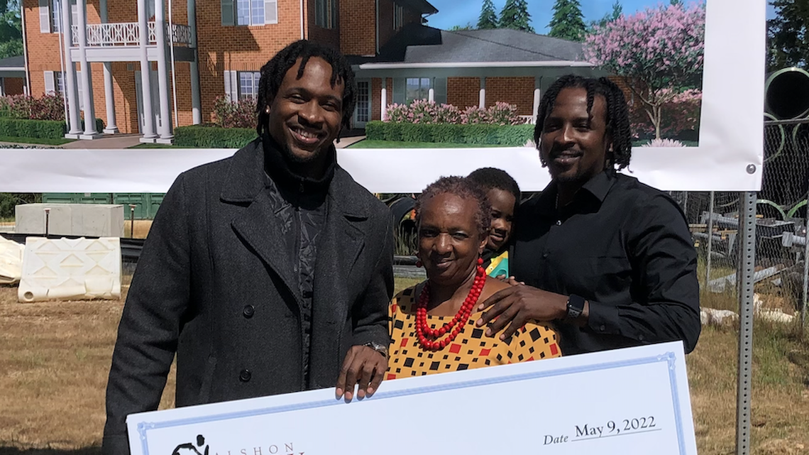 Former South Carolina star Alshon Jeffery (left) poses with a check he presented to members of the Columbia Fisher House Foundation with his mother, Deloris, and his brother, Shamier, who also played football at USC, on Monday, May 9, 2022.