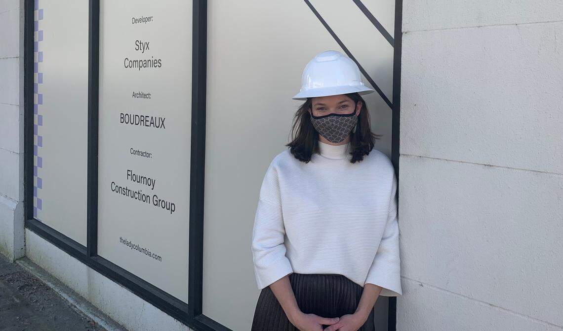 Julie Tuttle, a developer with Styx Company in Columbia, S.C., stands in front of the nearly completed The Lady apartment building on the corner of Lady and Sumter streets.